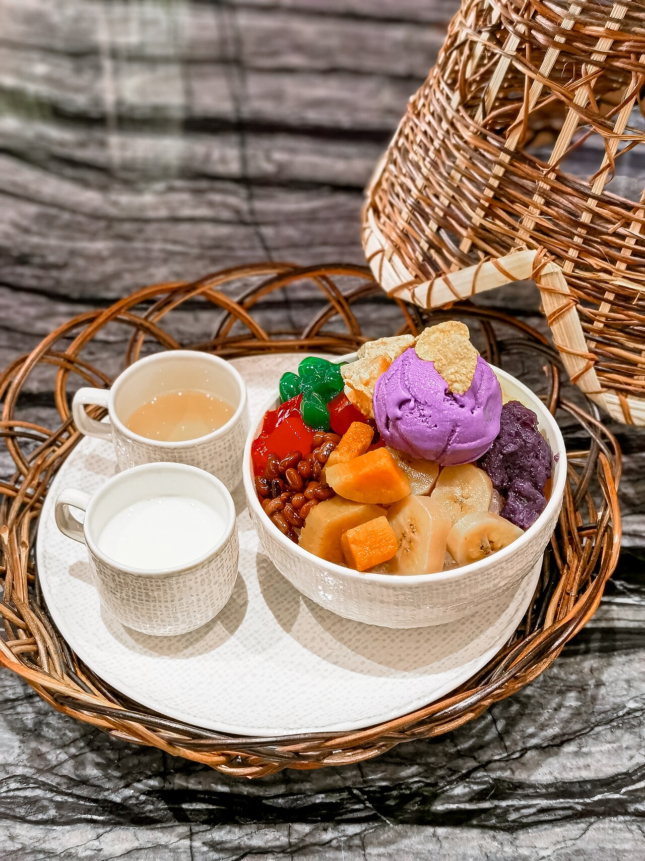 A bowl of Filipino halo-halo topped with a scoop of ube ice cream